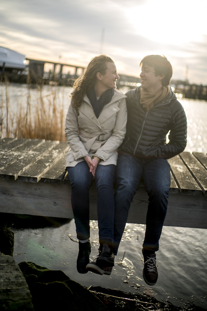 Lily and Greg sit on a dock in the wintertime, looking forward to warmer weather.